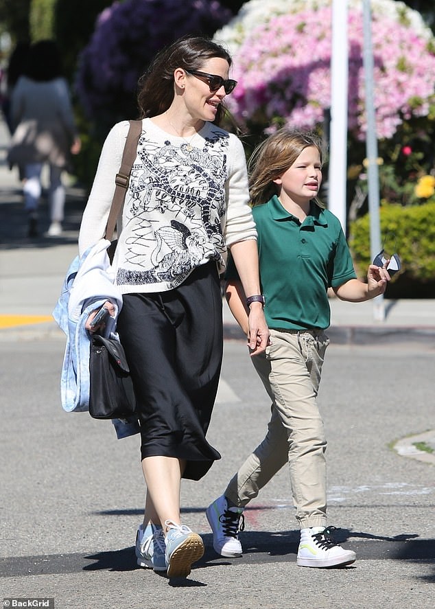 Polka dot mom: Jennifer droeg een grafisch T-shirt met een zwarte rok en sneakers