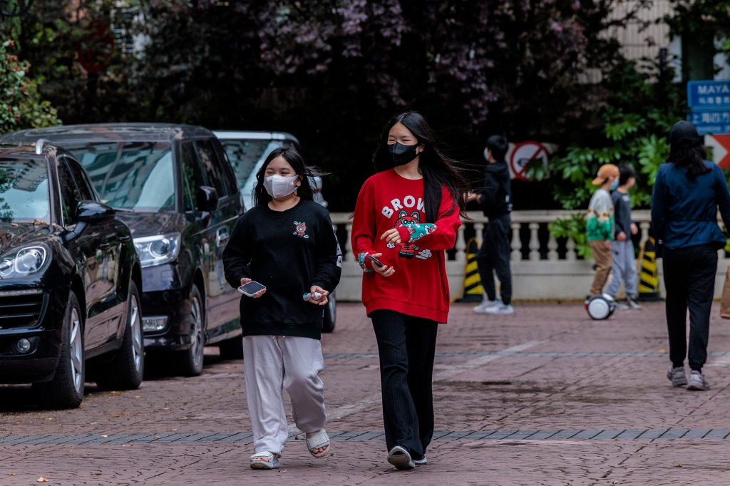 Mensen lopen door een residentiële gemeenschap in lockdown in Shanghai, China, 23 april 2022.