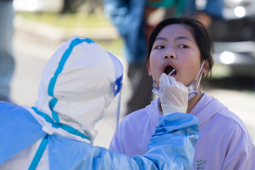Een meisje wordt op 22 april 2022 in Shanghai, China, in haar mond afgeveegd voor een COVID-19-test.