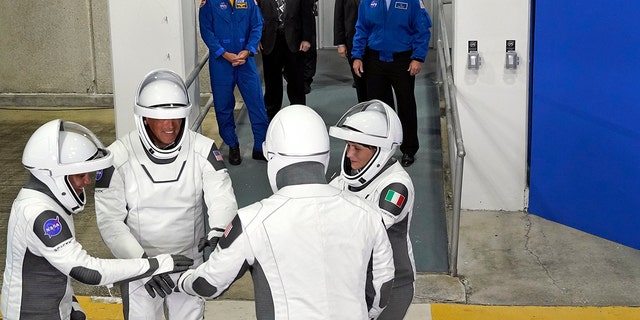 SpaceX Crew-4-astronauten, links, missiespecialist Jessica Watkins, piloot Bob Hines, commandant Kjell Lindgren en missiespecialist ESA-astronaut Samantha Cristoforetti uit Italië, verzamelen zich na het verlaten van het operatiegebouw en de voortstuwing voor een vlucht naar het lanceercomplex. Een woensdag 27 april 2022, in het Kennedy Space Center in Cape Canaveral, Florida.