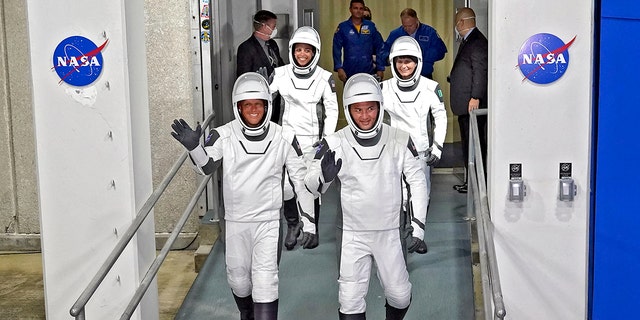 SpaceX Crew-4-astronauten, links, piloot Bob Hines, missiespecialist Jessica Watkins, commandant Kjell Lindgren en Europese astronaut Samantha Cristoforetti, uit Italië, zwaaien als ze het Operations Building verlaten en aan boord gaan van een vlucht naar Launch Complex 39 - woensdag 27 april 2022 , in het Kennedy Space Center in Cape Canaveral, Florida. 