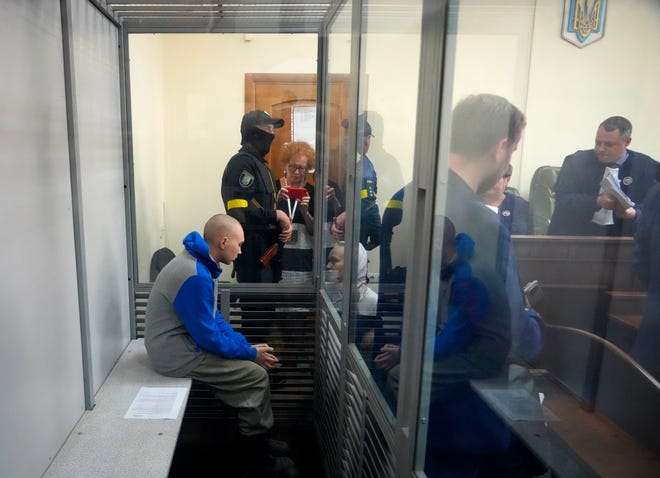 Sergeant Vadim Shishmarin, 21, wordt achter een glas gezien tijdens een rechtszitting in Kiev, Oekraïne, vrijdag 13 mei 2022. Het proces tegen een Russische soldaat die wordt beschuldigd van het doden van een Oekraïense burger begon vrijdag, het eerste proces tegen oorlogsmisdaden sinds Moskou's invasie van zijn buurland.