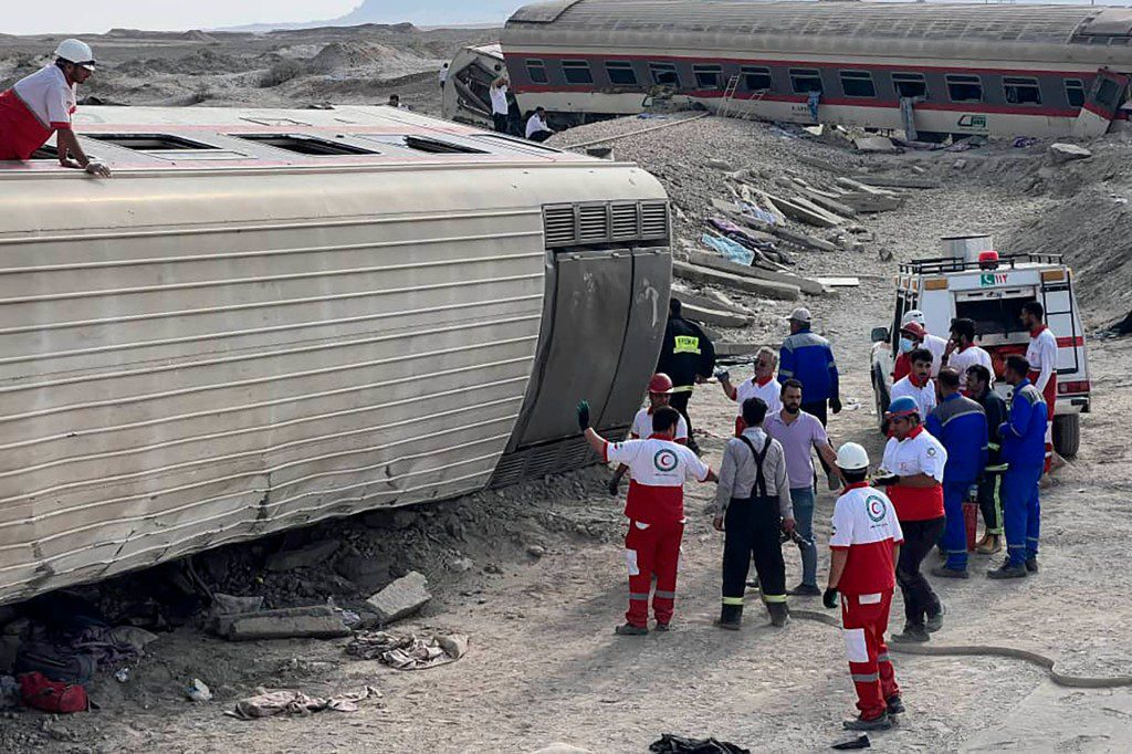 Reddingswerkers van de Iraanse Rode Halve Maan werken op de plek van de ontsporing.