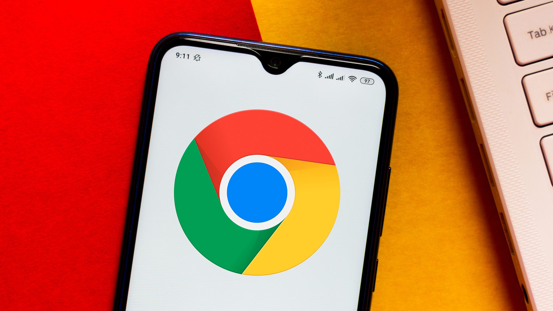 Het Google Chrome-logo dat op een Android-smartphone wordt weergegeven, rust op een oranje en rood oppervlak