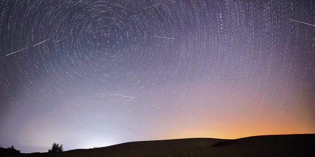 De samengestelde afbeelding, gemaakt op 13 augustus 2021, toont de nachtelijke hemel tijdens de Perseïden-meteorenregen boven het ecologische demonstratiegebied Ingbe in de Kubuki-woestijn, in de autonome regio Binnen-Mongolië in het noorden van China. 