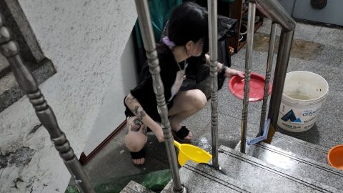 Een vrouw schept op 10 augustus water uit een ondergelopen kelderappartement in Seoel, Zuid-Korea.