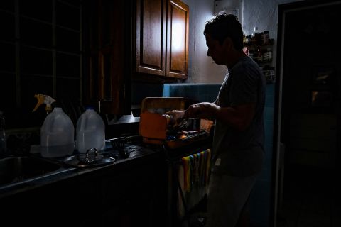 Een persoon kookt maandag in het donker nadat hij de stroom heeft uitgevallen in San Juan, Puerto Rico.