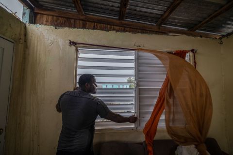 Nelson Sereno beveiligt de ramen van zijn huis terwijl de wind van orkaan Fiona zondag in Louisa waait.