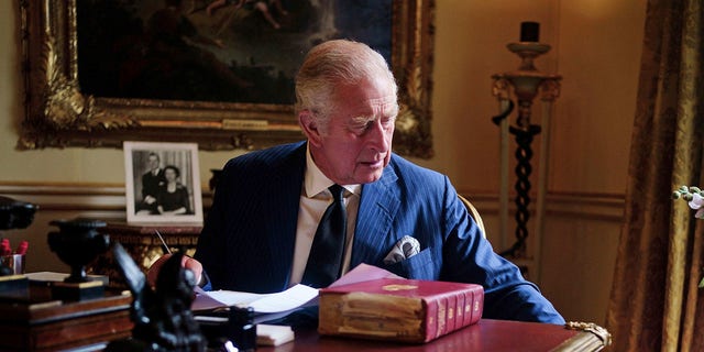 Op deze foto van 11 september 2022 voert de Britse koning Charles III officiële overheidstaken uit vanuit zijn rode borst in de 18e-eeuwse kamer in Buckingham Palace, Londen.  (Victoria Jones/PA via AP)