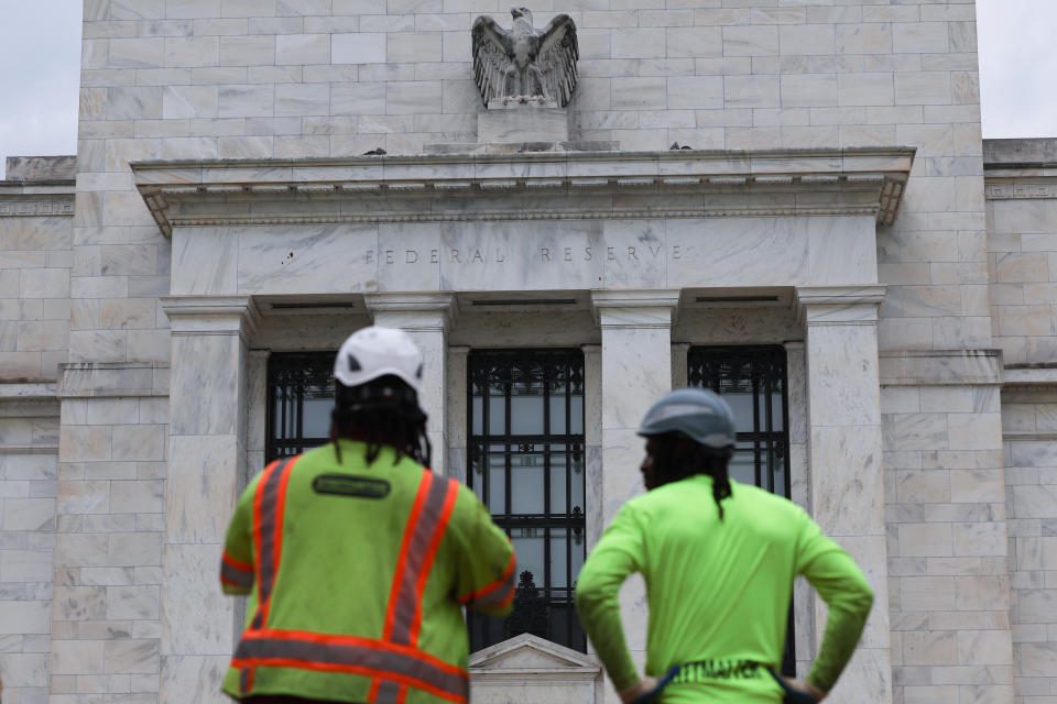 WASHINGTON, DC - 26 JULI: Bouwvakkers kijken buiten het Marriner S. Eccles Federal Reserve-gebouw op 26 juli 2022 in Washington, DC.  Ambtenaren van het Federal Open Market Committee (FOMC) houden een tweedaagse bijeenkomst waar de Federal Reserve deze week naar verwachting de rente opnieuw zal verhogen om de inflatie te bestrijden.  (Foto door Anna Moneymaker/Getty Images)