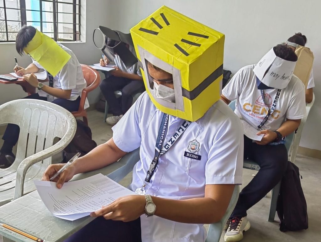 Er zijn foto's van Filippijnse studenten die anti-fraudehoeden dragen