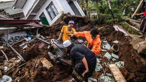 Dorpelingen redden spullen uit beschadigde huizen na een aardbeving met een kracht van 5,6 op de schaal van Richter op 22 november 2022 in Cianjur. 