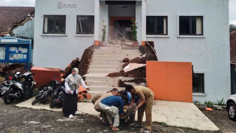 Gemeenteambtenaren in Cianjur evacueren een gewonde collega in de nasleep van de aardbeving.
