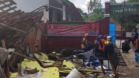 Arbeiders inspecteren een door een aardbeving beschadigde school in Cianjur, West-Java.
