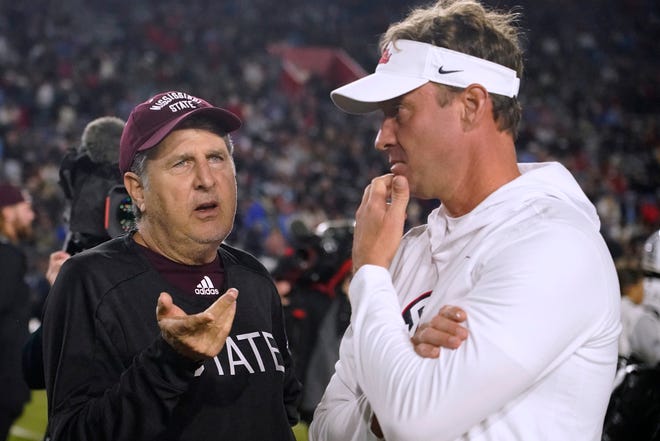 Mississippi State-coach Mike Leach, links, spreekt met Mississippi State-coach Lane Kiffin voor de NCAA college football-wedstrijd in Oxford op donderdag 24 november.