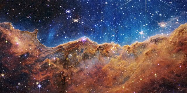 Wat op een maanverlichte avond veel lijkt op rotsachtige bergen, is in werkelijkheid de rand van het nabije, jonge stervormingsgebied NGC 3324 in de Carinanevel.  Deze afbeelding, gemaakt in infrarood licht door de Near Infrared Camera (NIRCam) van NASA's James Webb Space Telescope, onthult eerder verduisterde gebieden van stergeboorte.